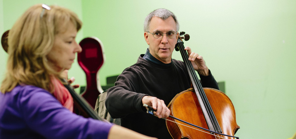 Cello instructor Steven Wiggs demonstrates a phrase for a Bridges student